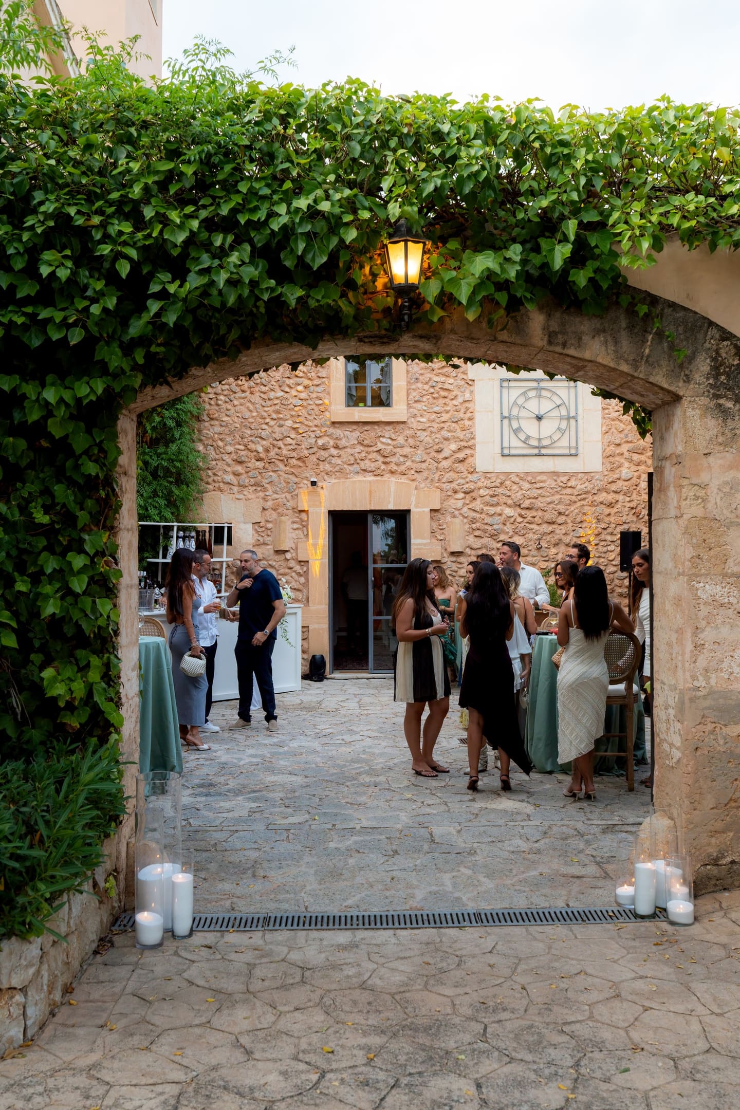 Guests gathering with drinks in the arched courtyard of a finca
