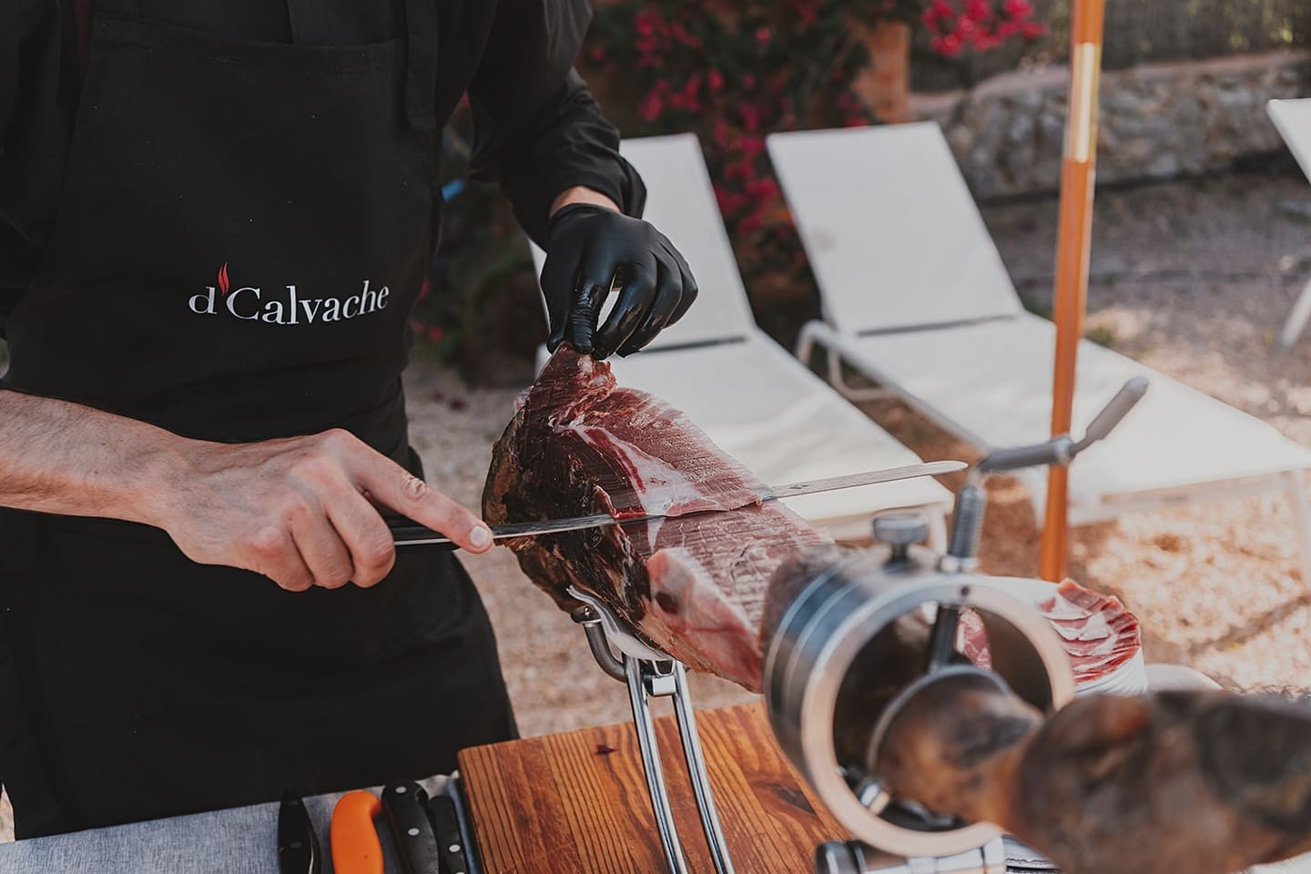 A chef hand-carving Iberian ham at a carving station