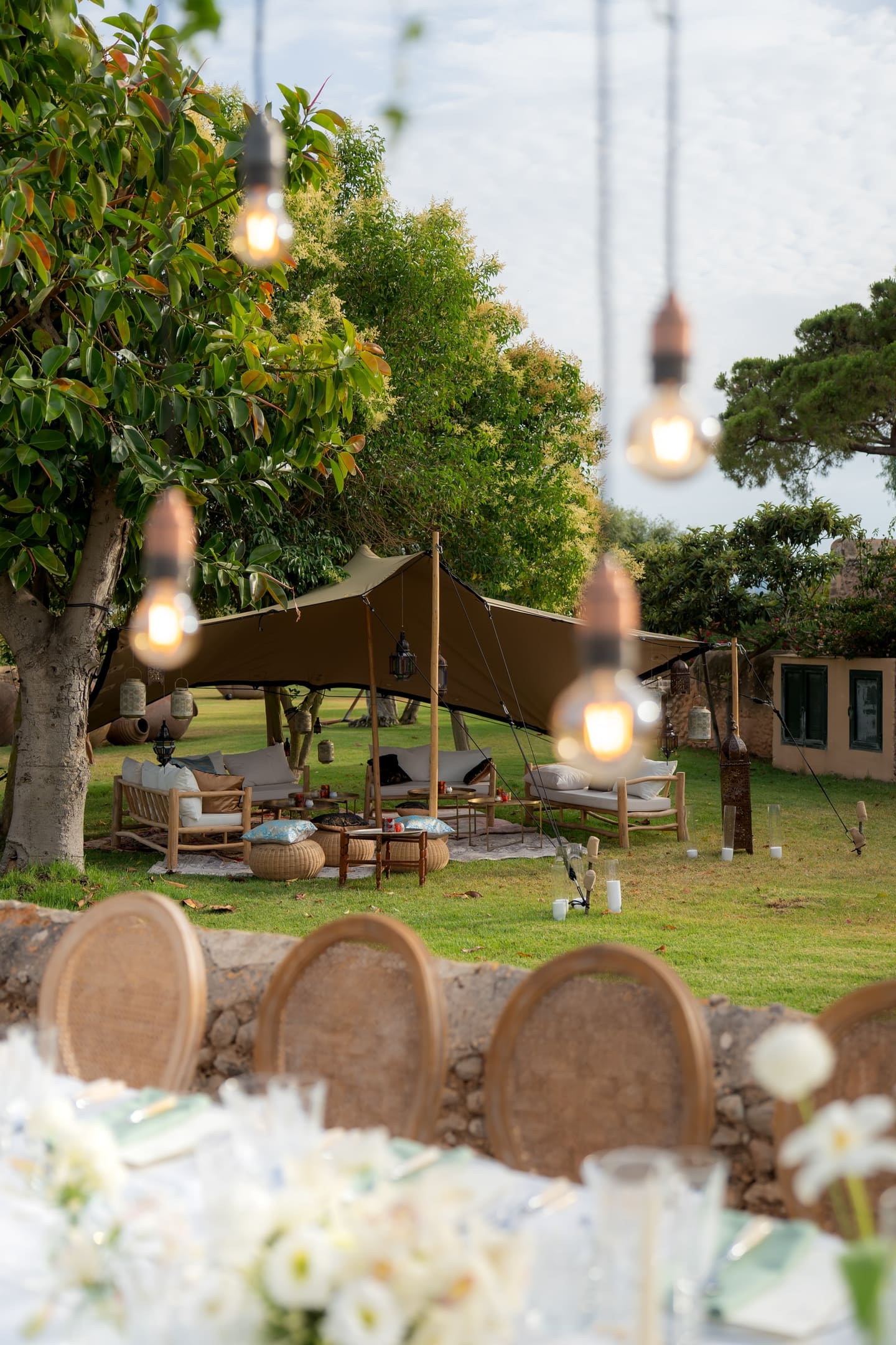 A lounge tent with sofas and lanterns set on a finca lawn