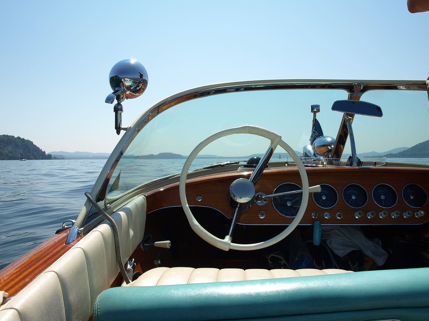 The wooden dashboard and wheel of a classic Riva motorboat on the Mediterranean