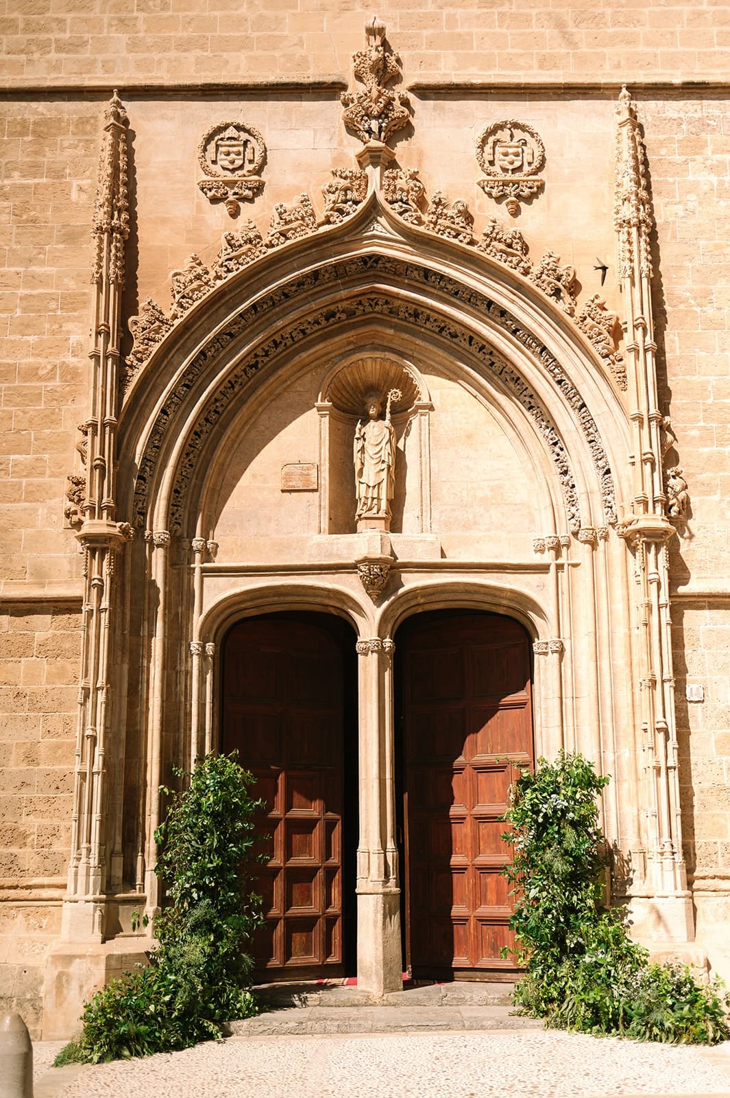 The carved Gothic stone doorway of a church in Palma in warm afternoon light