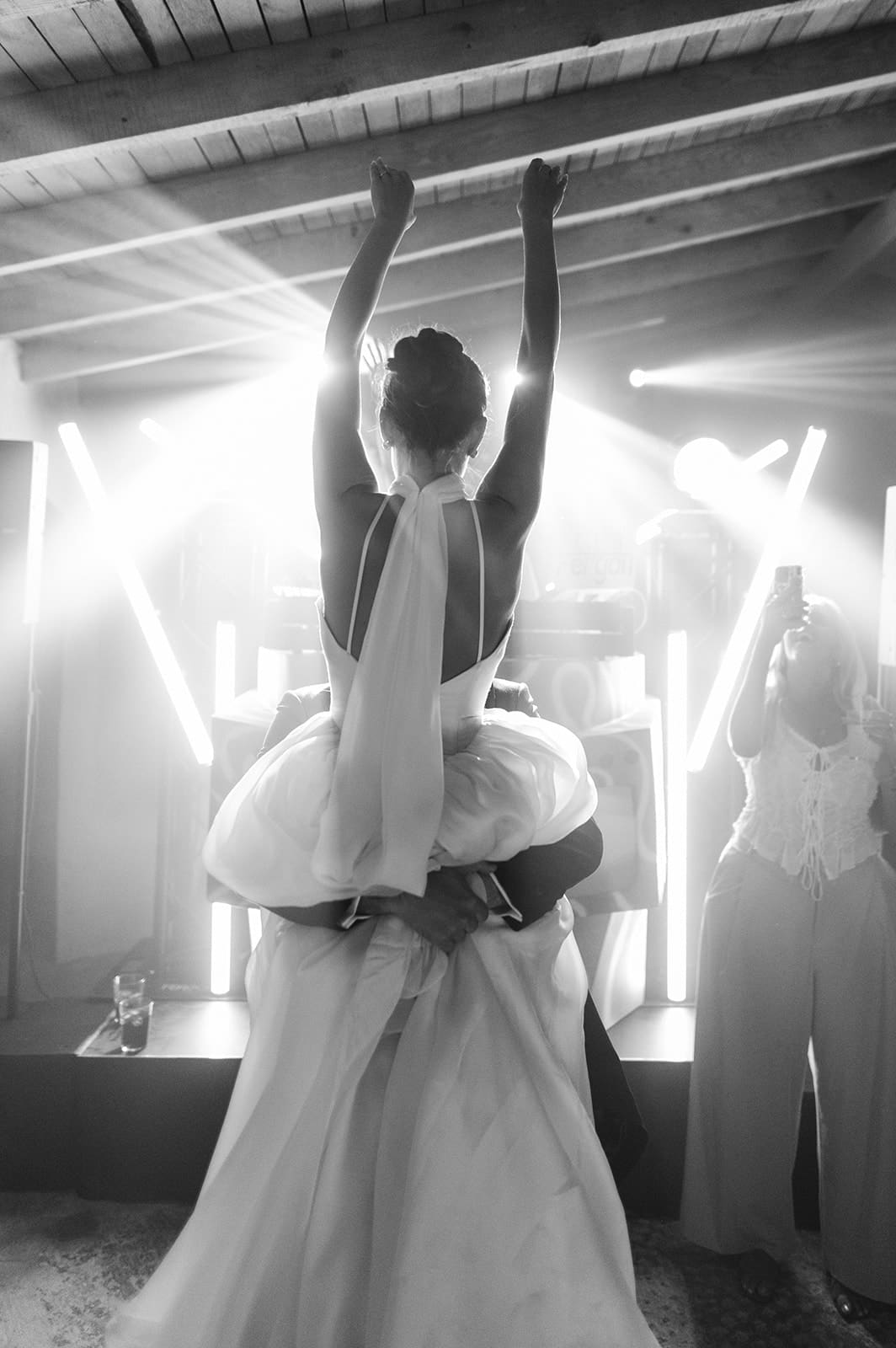 A bride in a white dress photographed in black and white among light streaks